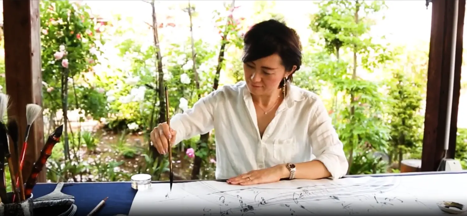 Traditional Japanese calligraphy tools: an inkstone, a sumi ink stick, and brushes made of natural bamboo and animal hair.