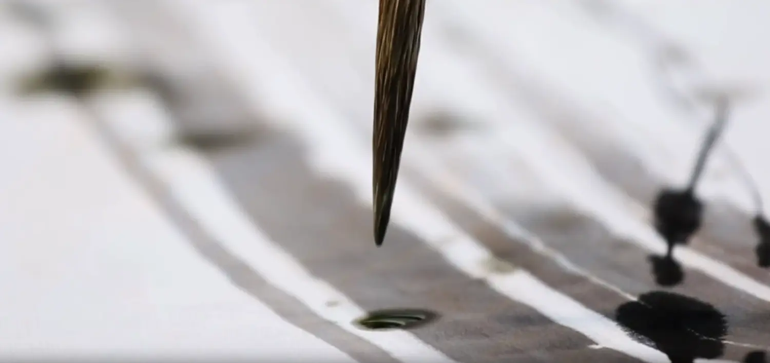 A luxury living room wall featuring a framed original calligraphy piece, highlighted by a spotlight