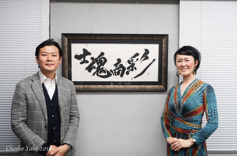 A sophisticated CEO office with a large desk and a powerful calligraphy piece hanging behind the executive chair.